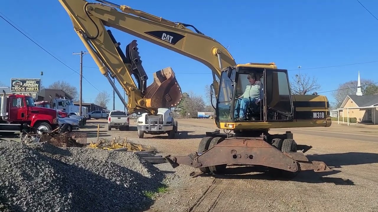 CAT M318 BEING OPERATED