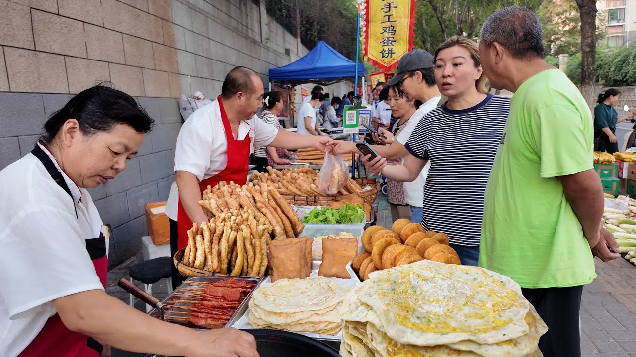山东济南最经典的街头早市，每天营业2个小时，肉夹馍香气四溢，地道煎饼果子，鸡蛋灌饼外酥里嫩，鸡蛋煎饼，中国北方人最爱的葱花烙饼，蔬菜煎饼金黄酥脆，经典早餐豆腐脑，人气爆满的水煎包。