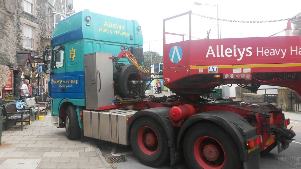 Train squeezes through narrow Barmouth streets on a lorry following fire on Barmouth Beach