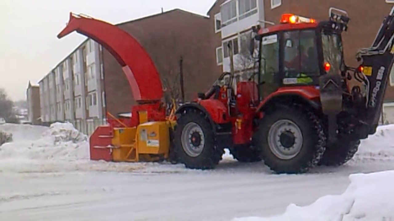 Huddig 1060B med Overaasen snöslunga kör undan snövallar