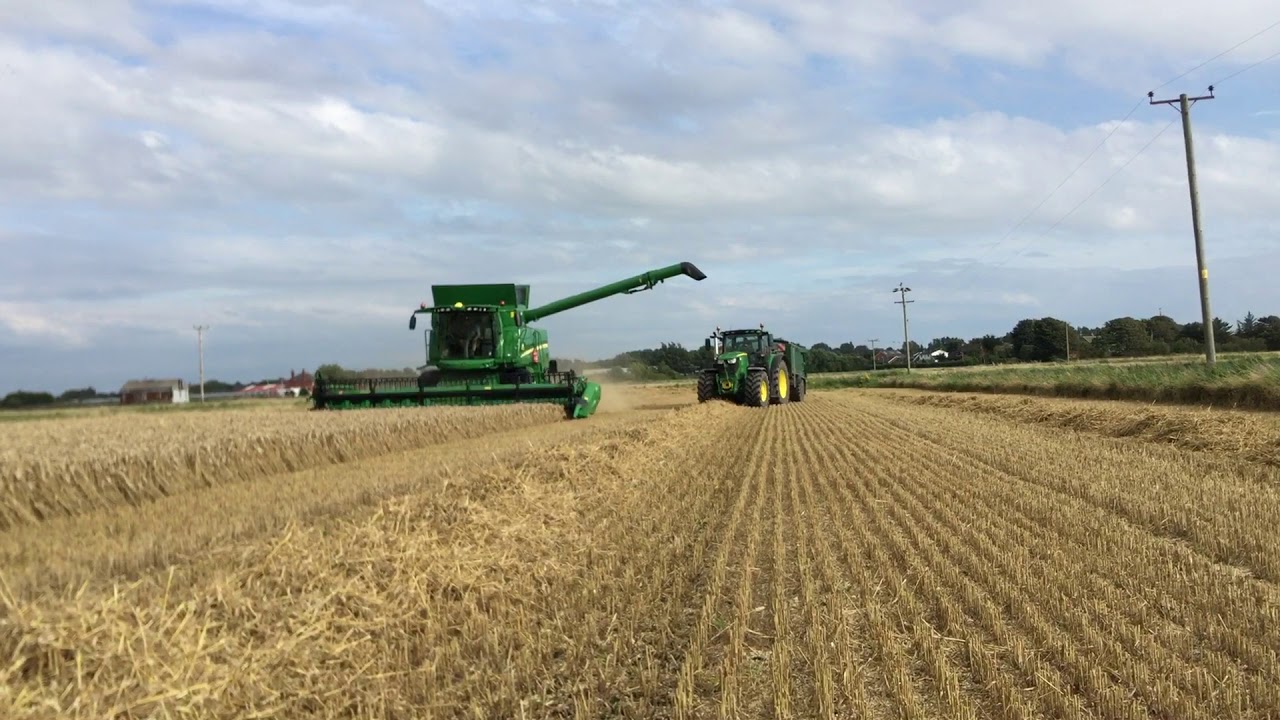 John Deere T560i combine harvester unloading on the go