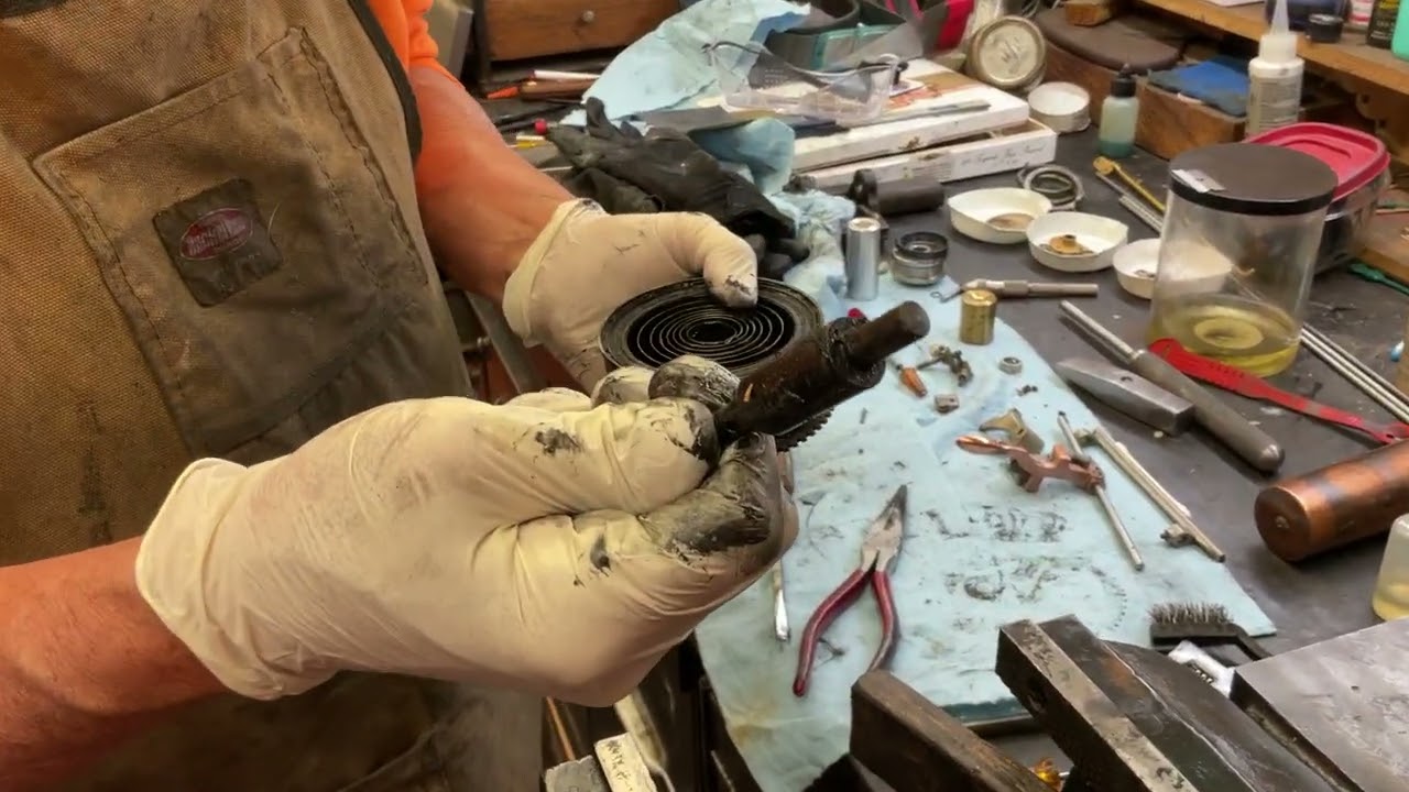 1696.  Removing the Victor II phonograph mainspring from the spring barrel. ￼