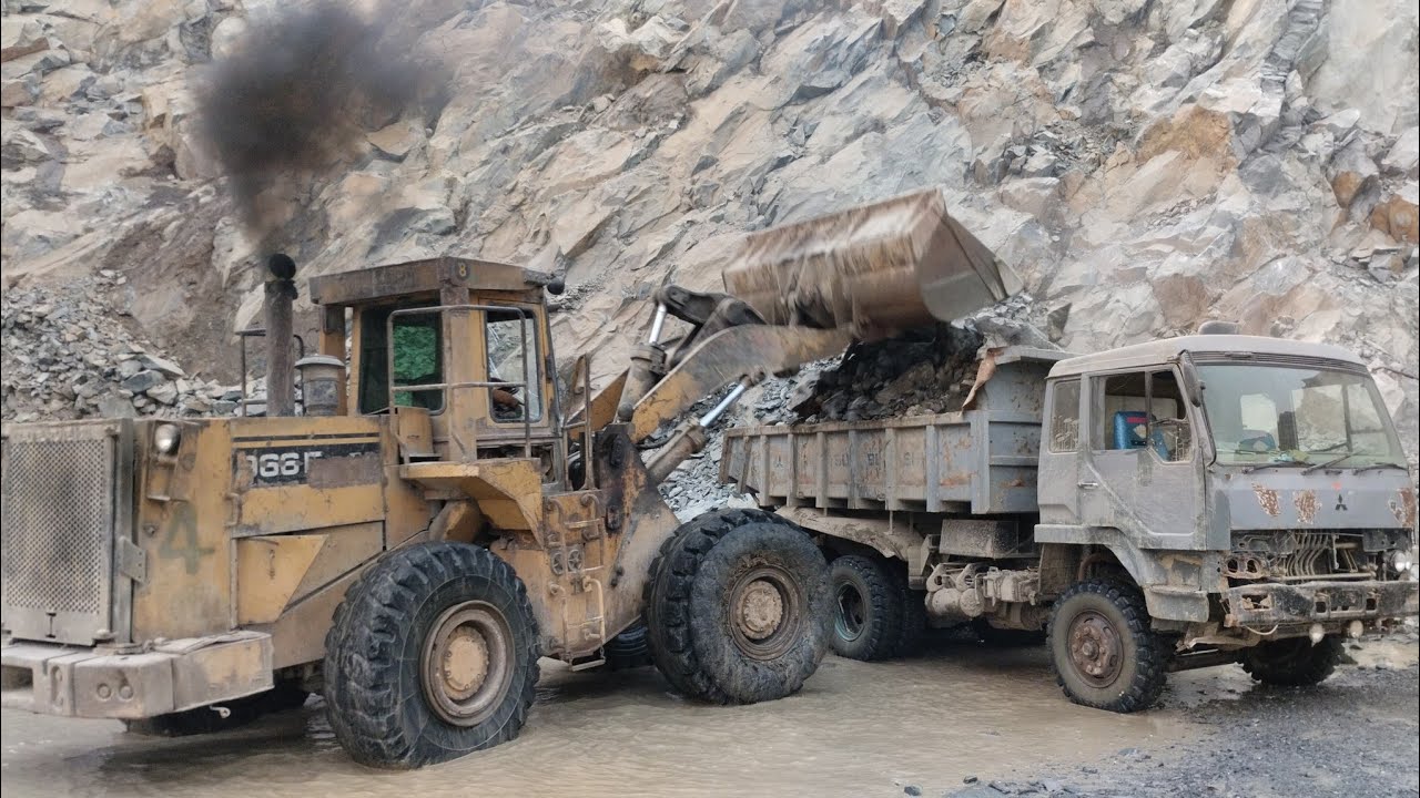 Powerful Caterpillar 966E Wheel Loader Loading Giant Rocks into Mitsubishi Dump Trucks