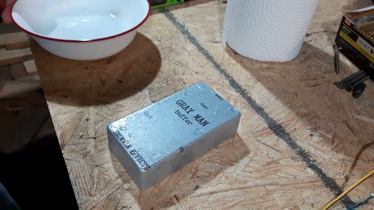 Applying a waterslide decal to a guitar pedal .