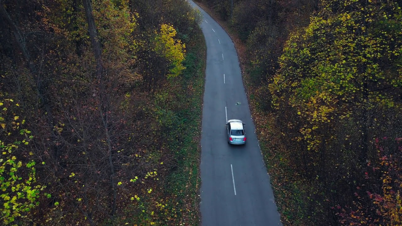 aerial view on car driving through autumn forest road scenic autumn landscape