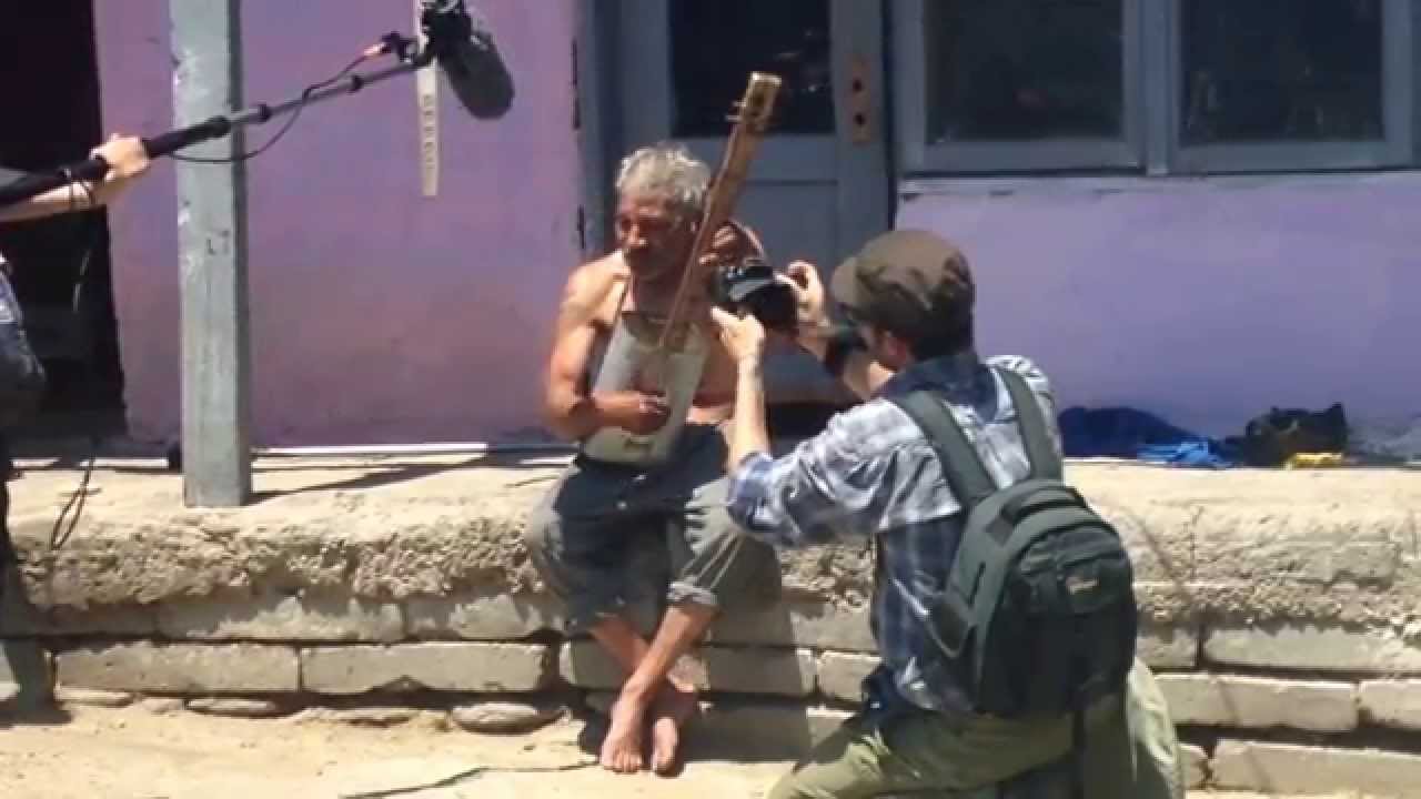 Roma musician playing strange instrument and singing in Kovachevo village, Bulgaria