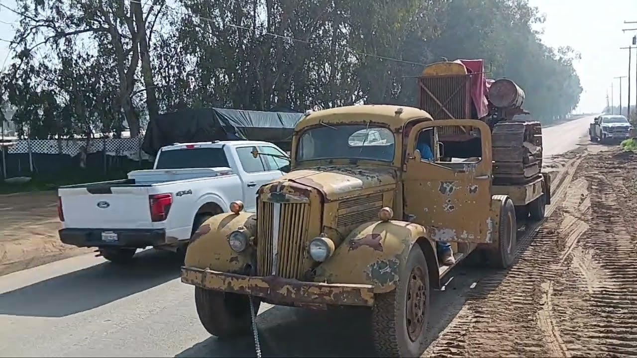 CATERPILLAR MODEL 341 D4 PULLING 1951 WHITE LOWBOY WITH A CAT 60 INTO STORAGE