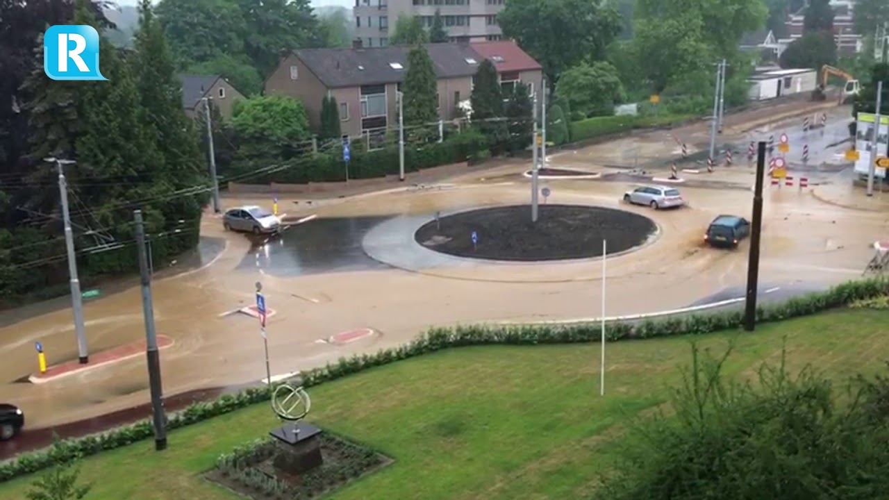 Straten in Velp blank door zware regenbuien, zand over nieuwe rotonde