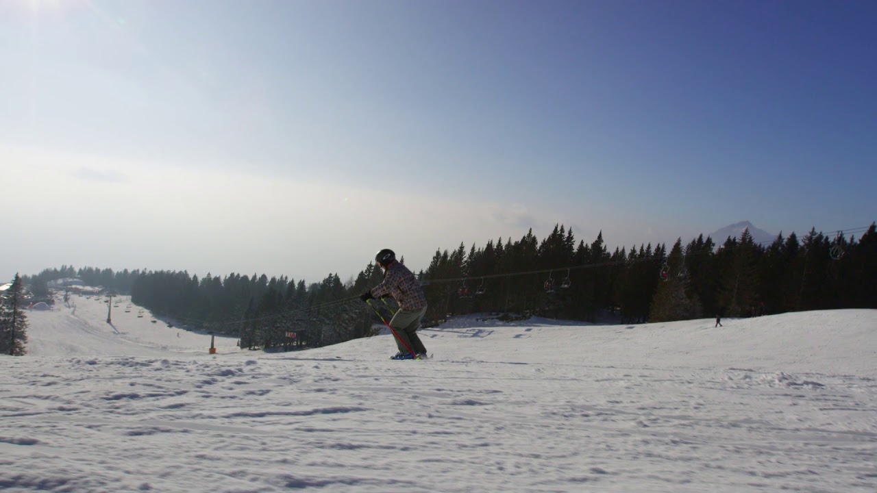 slow motion 4k silhouette of professional skier carving down on sunny winter day
