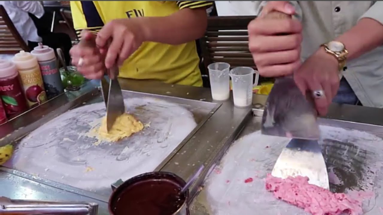 Two boys making ice cream roll in Thailand