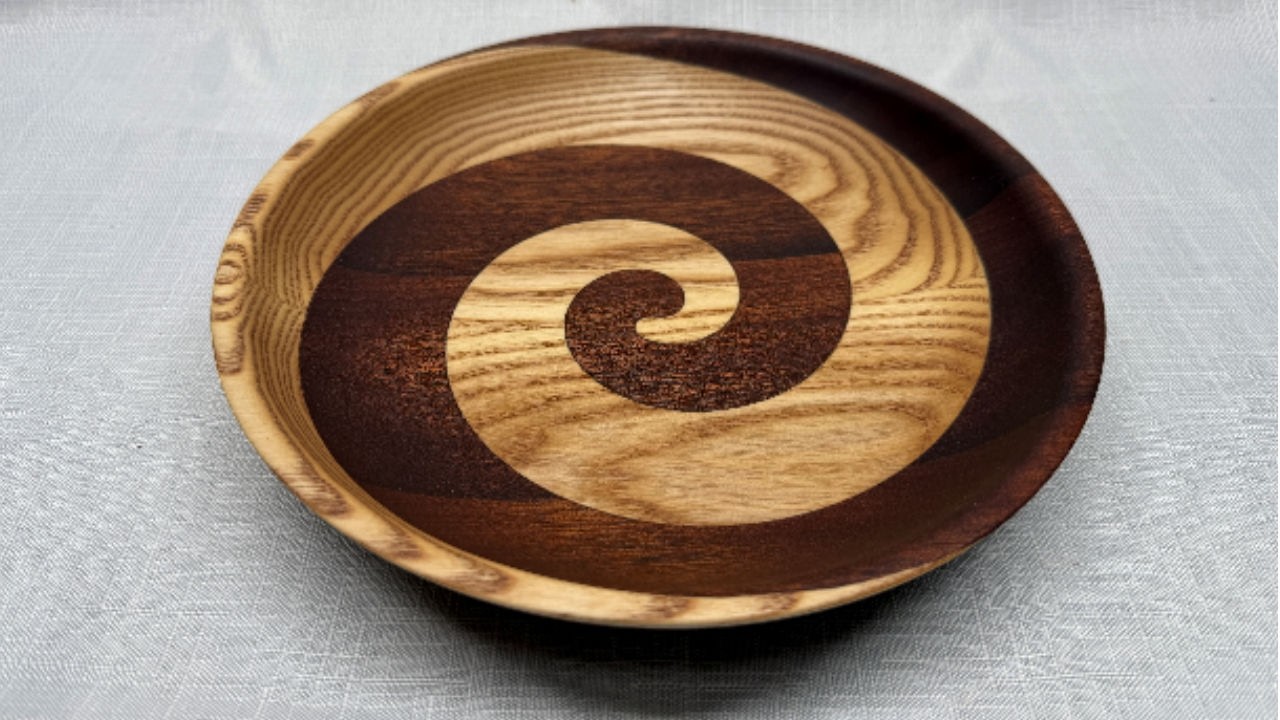 A turned bowl with a swirl pattern created from ash and sapele
