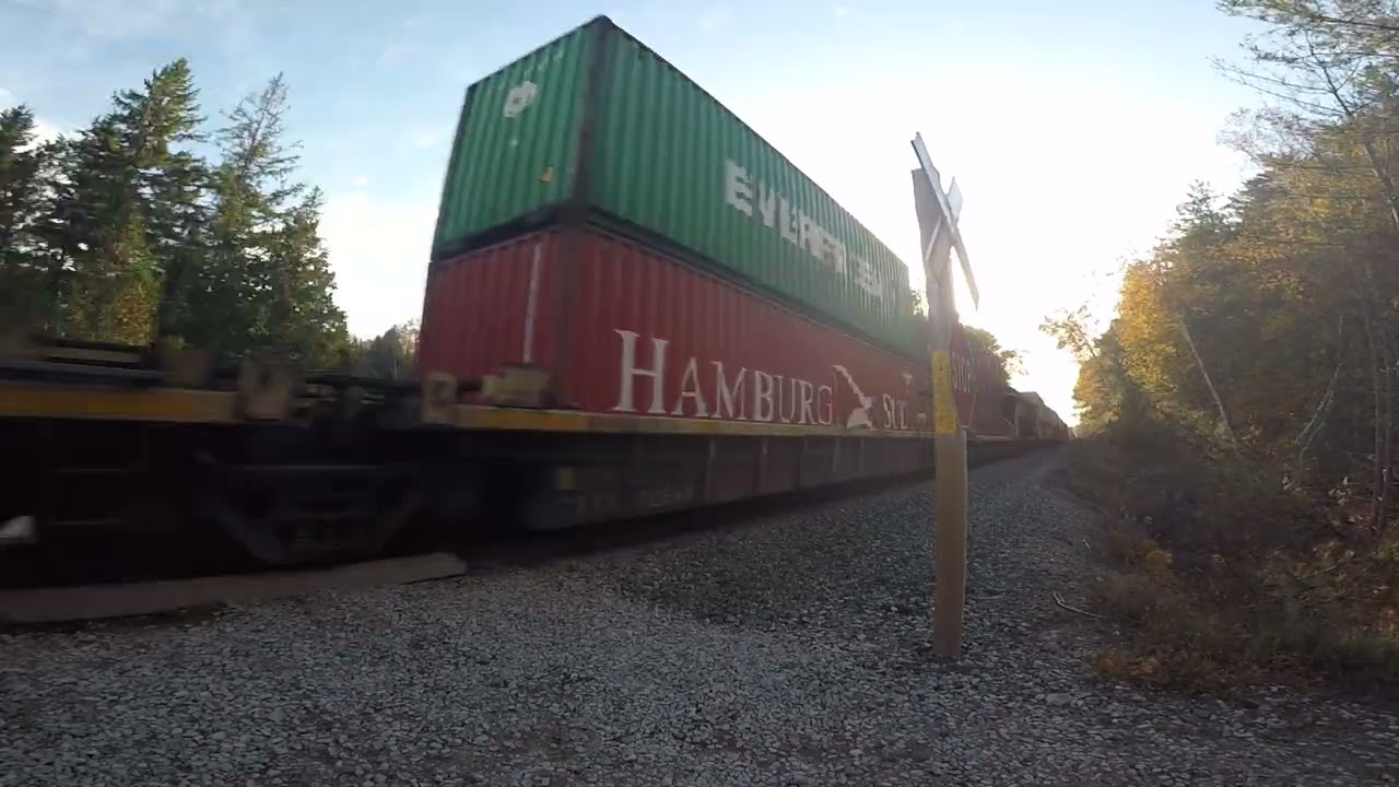 Copeland Forest Pedestrian railroad crossing CPKC unit leads intermodal past