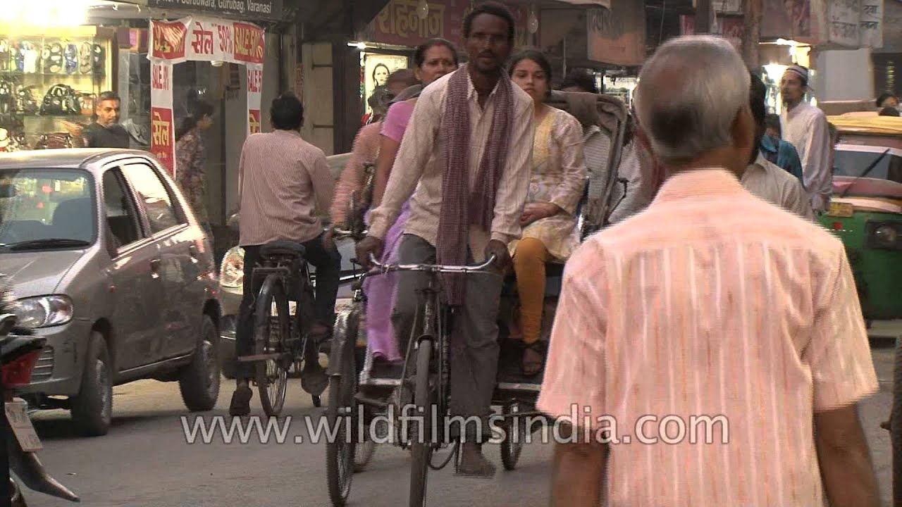 Cycle rickshaws and motor vehicles in a busy street in Varanasi, India
