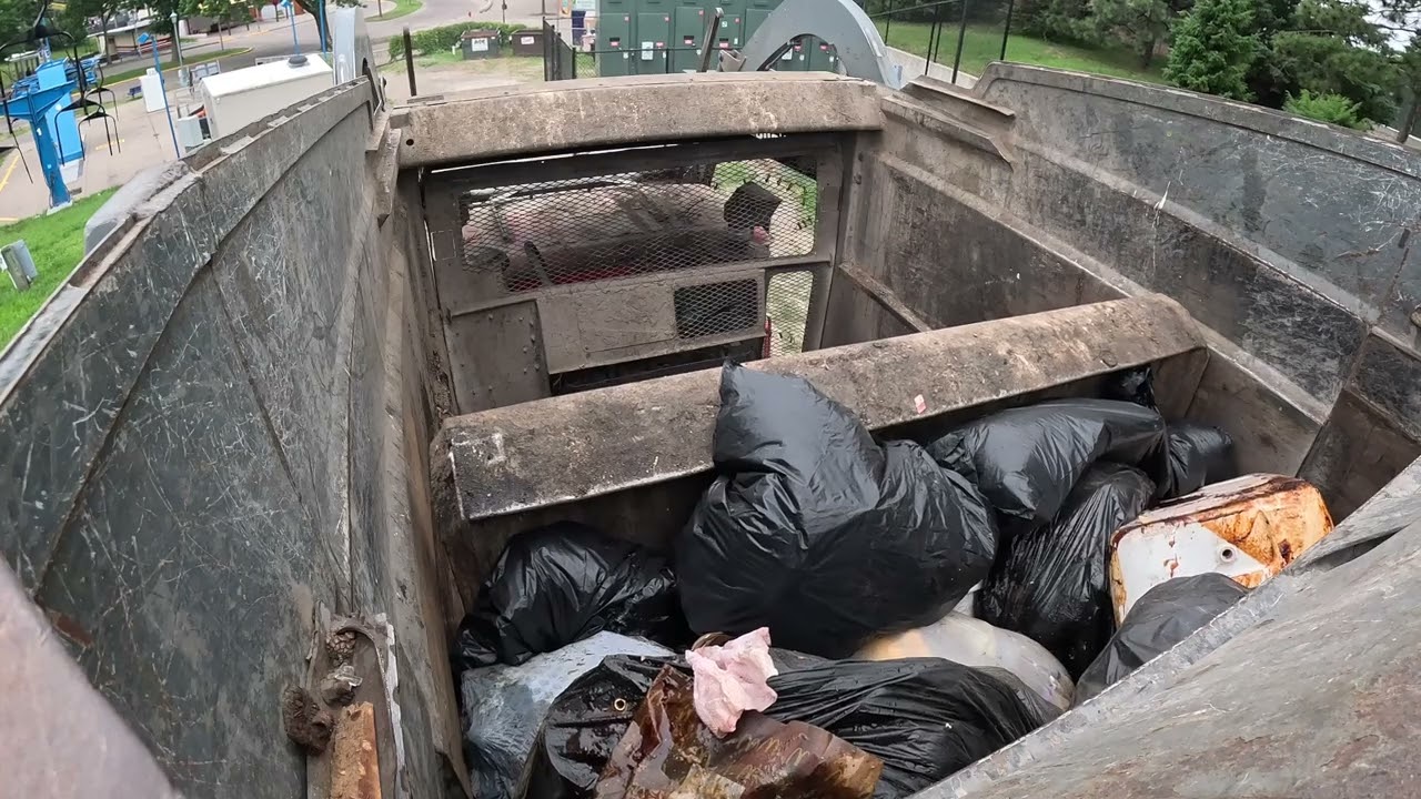 Garbage truck hopper POV: CNG McNeilus FL on full dumpsters