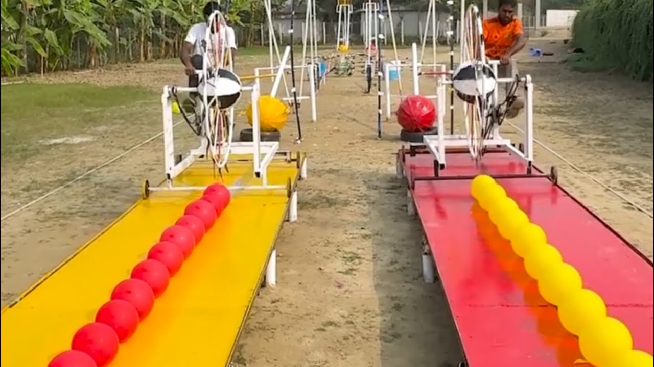 This is a challenge to two young men in a funny game of rolling a big football and bursting balloons