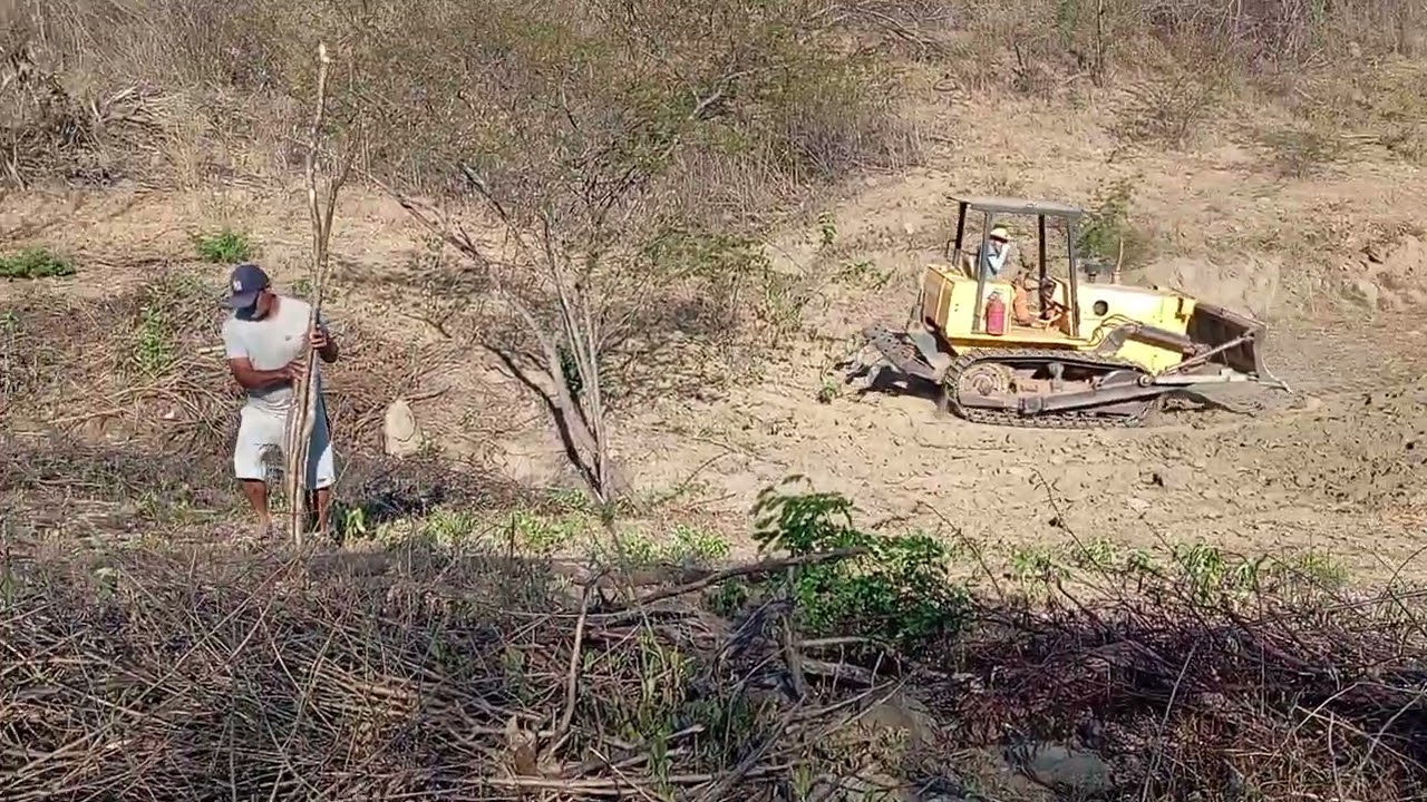 A máquina está fazendo o barreiro no nosso terreno.