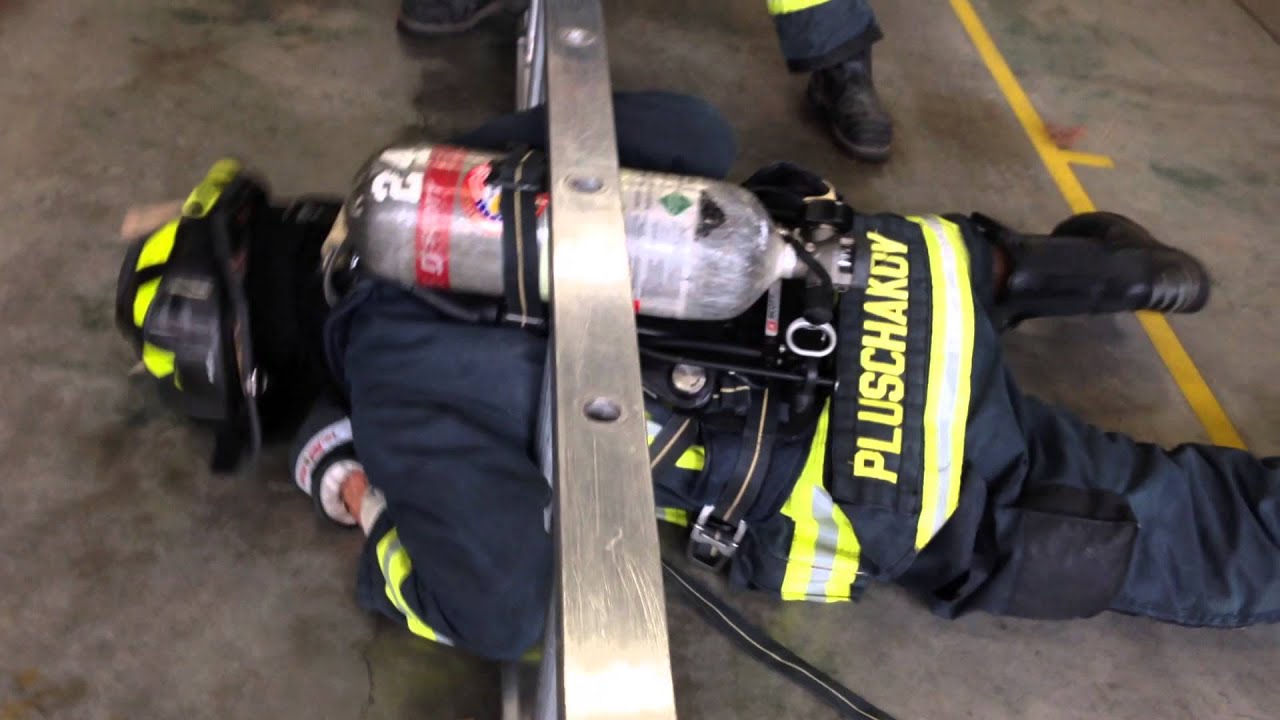 Firefighter fits through a ladder with an SCBA