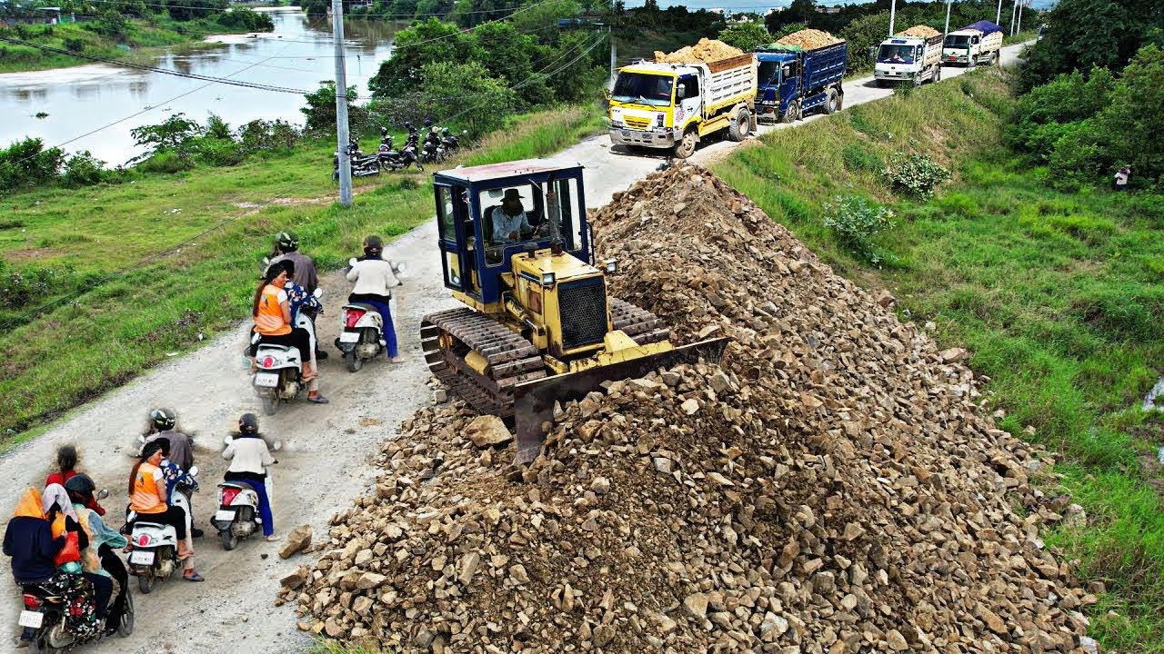 Amazing Stated Landfill Komatsu bulldozer pushes stone fill in deep land with Dump truck dumping