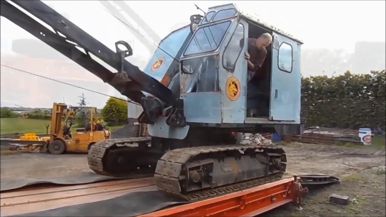 Vintage excavator and trailer. Old school loading. (Contains industrial language).