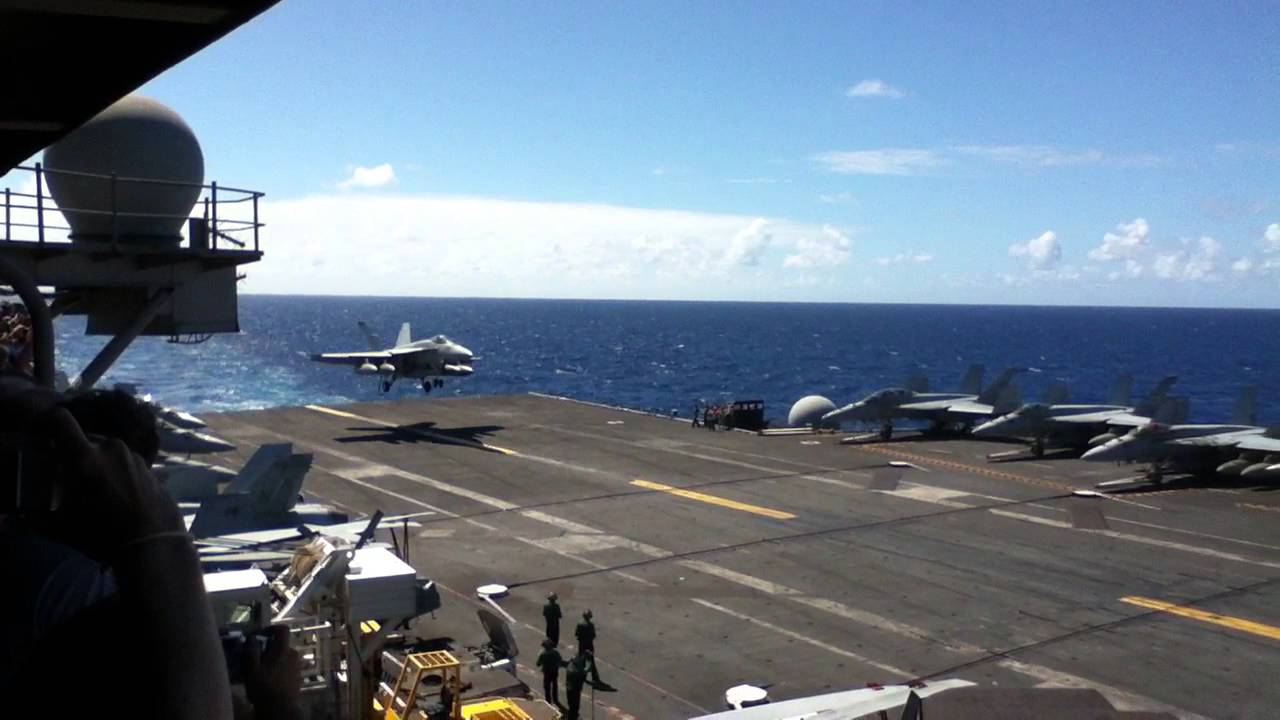 Navy fighter performs a tailhook landing on the USS Ronald Reagan somewhere in the Pacific Ocean