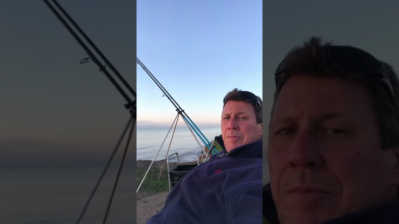 Early morning beach caster fishing cliff top