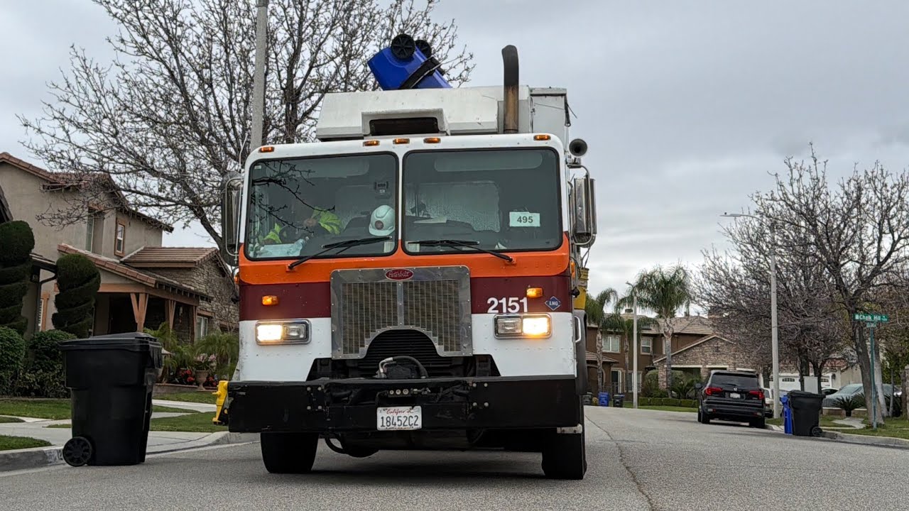  Burttec 2151 piking up blue bins I. The rain