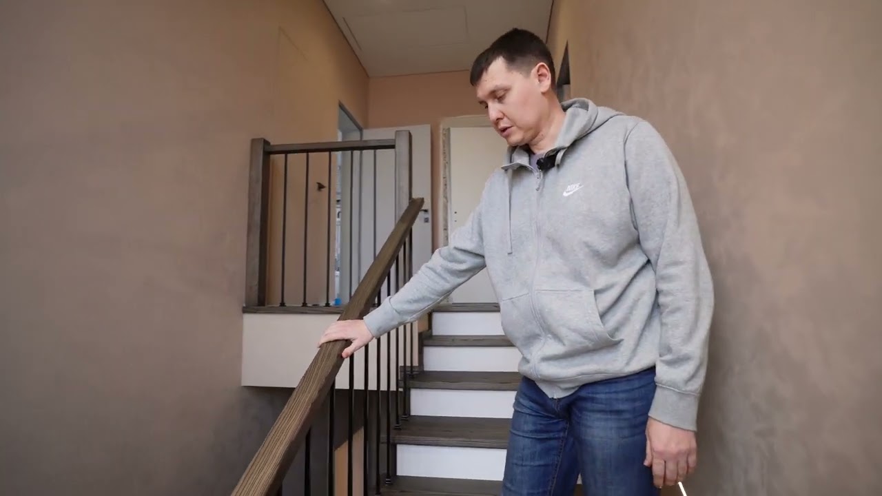 Закрытая П-образная лестница с подсветкой в стене, металлические балясины, деревянный поручень