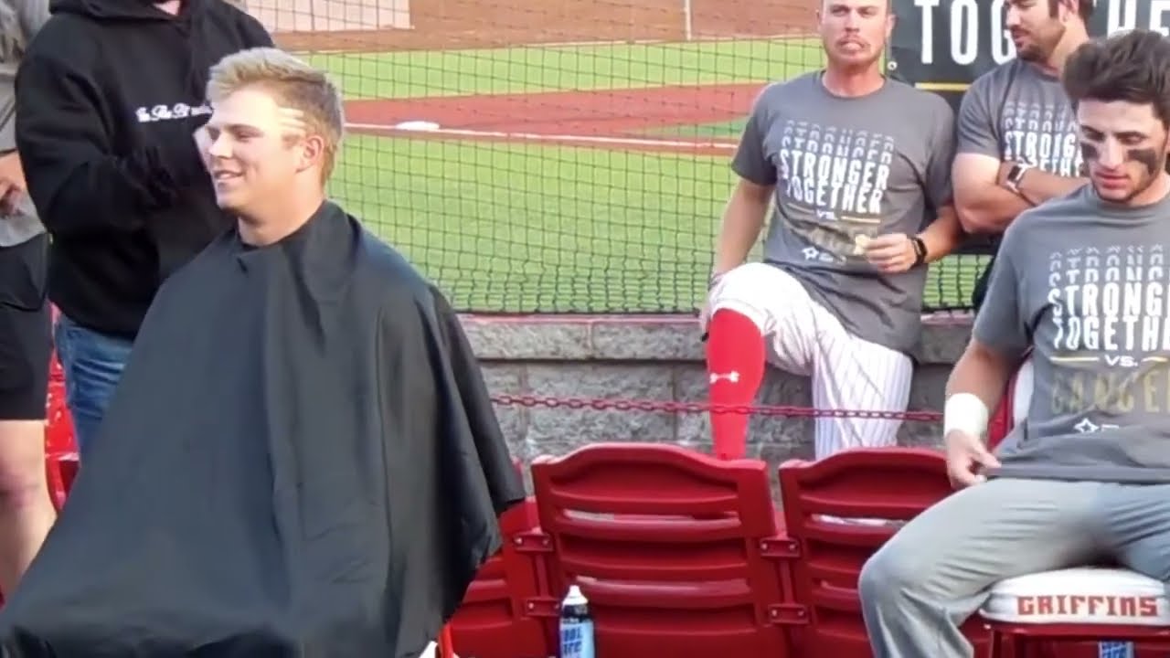 Baseball player gets his head shaved with his team