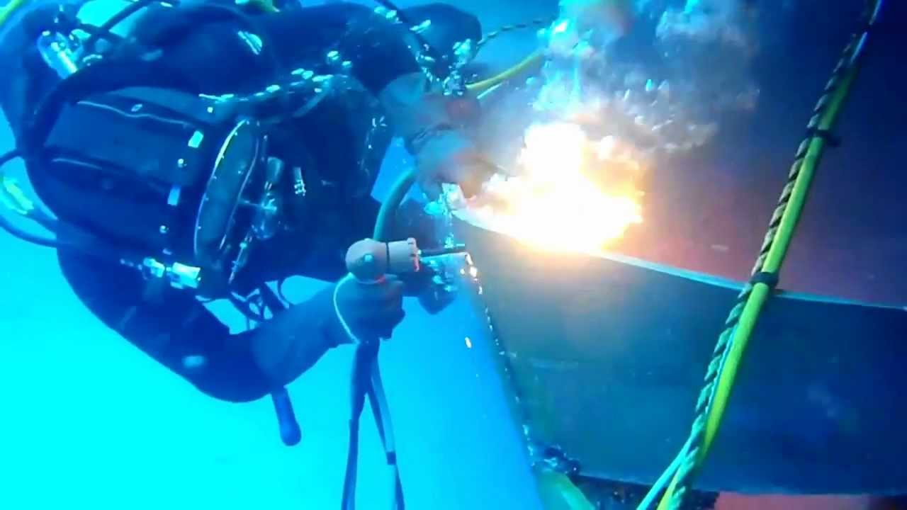 Commercial Diver burning off damaged steel plate underwater using 