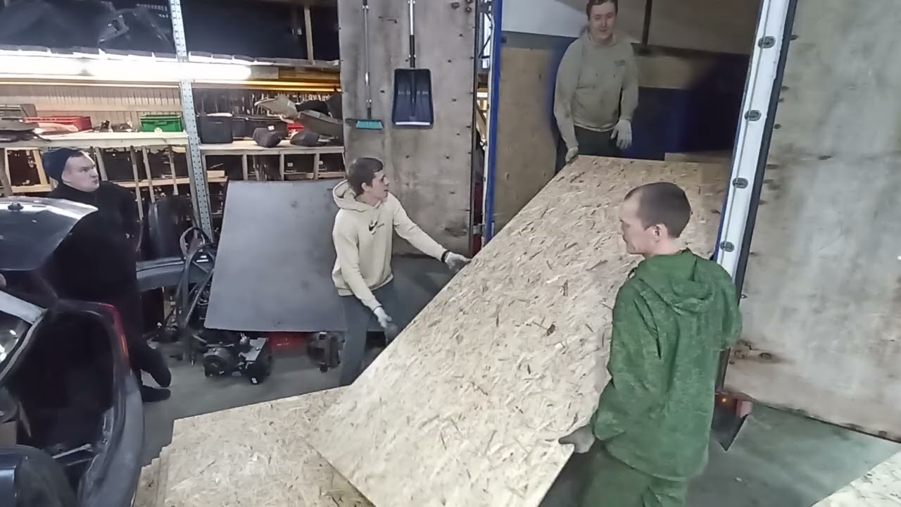 Men unload OSB at a warehouse | Auto dismantling