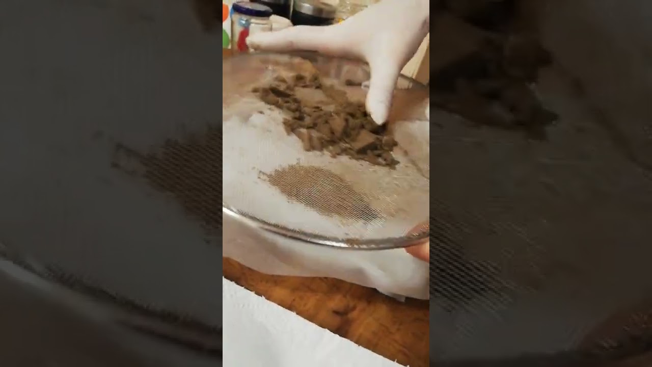 Ice water bubble hash being sieved over a dry  towel to evaporate out water faster.