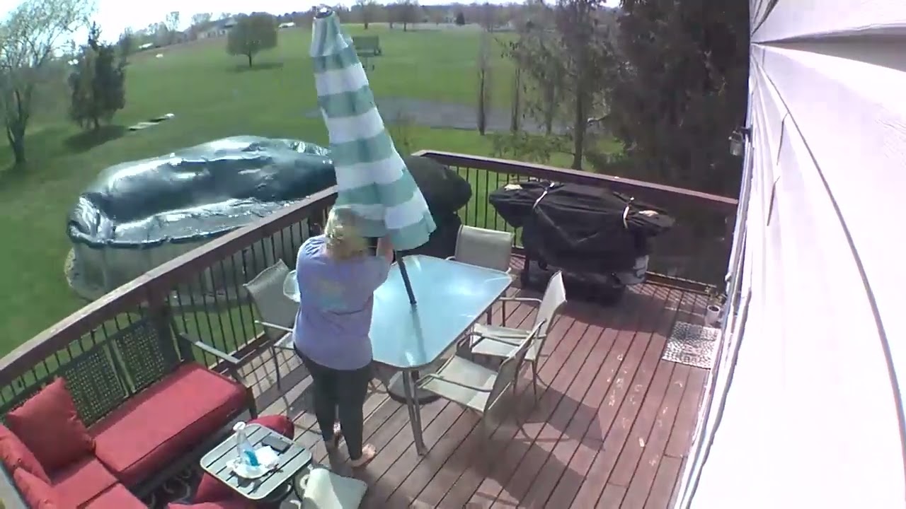 Woman Breaks Glass Table While Attempting to Set Up Umbrella During Storm - 1654396
