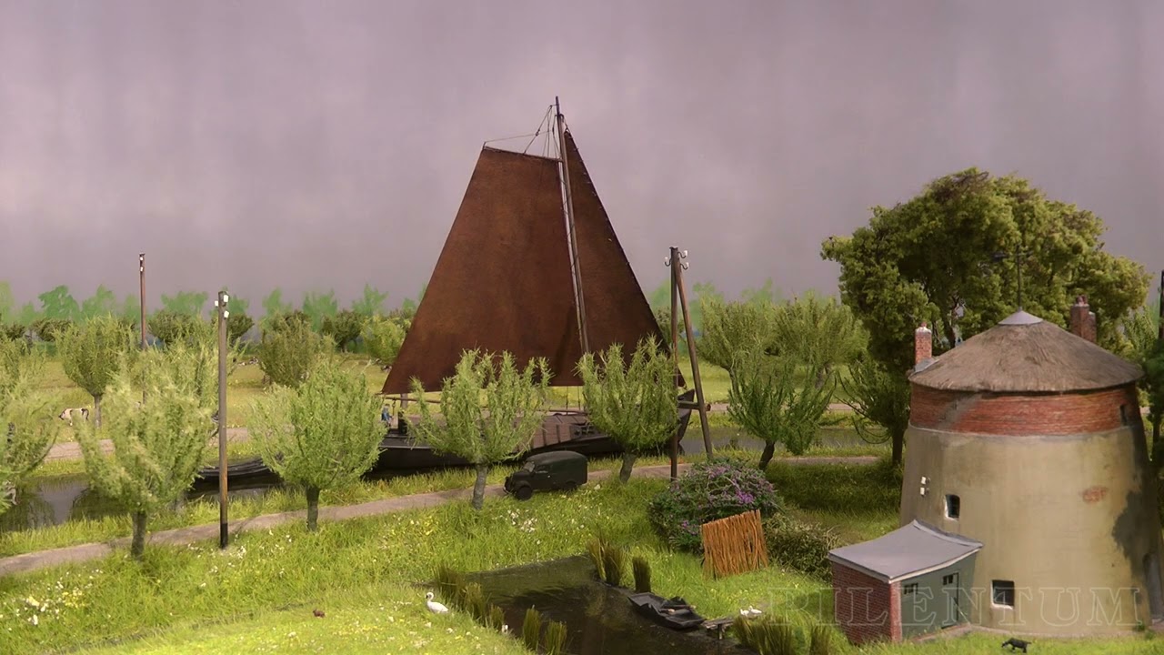 Очаровательная макет железной дороги с прекрасным пейзажем, кораблями и трамваями