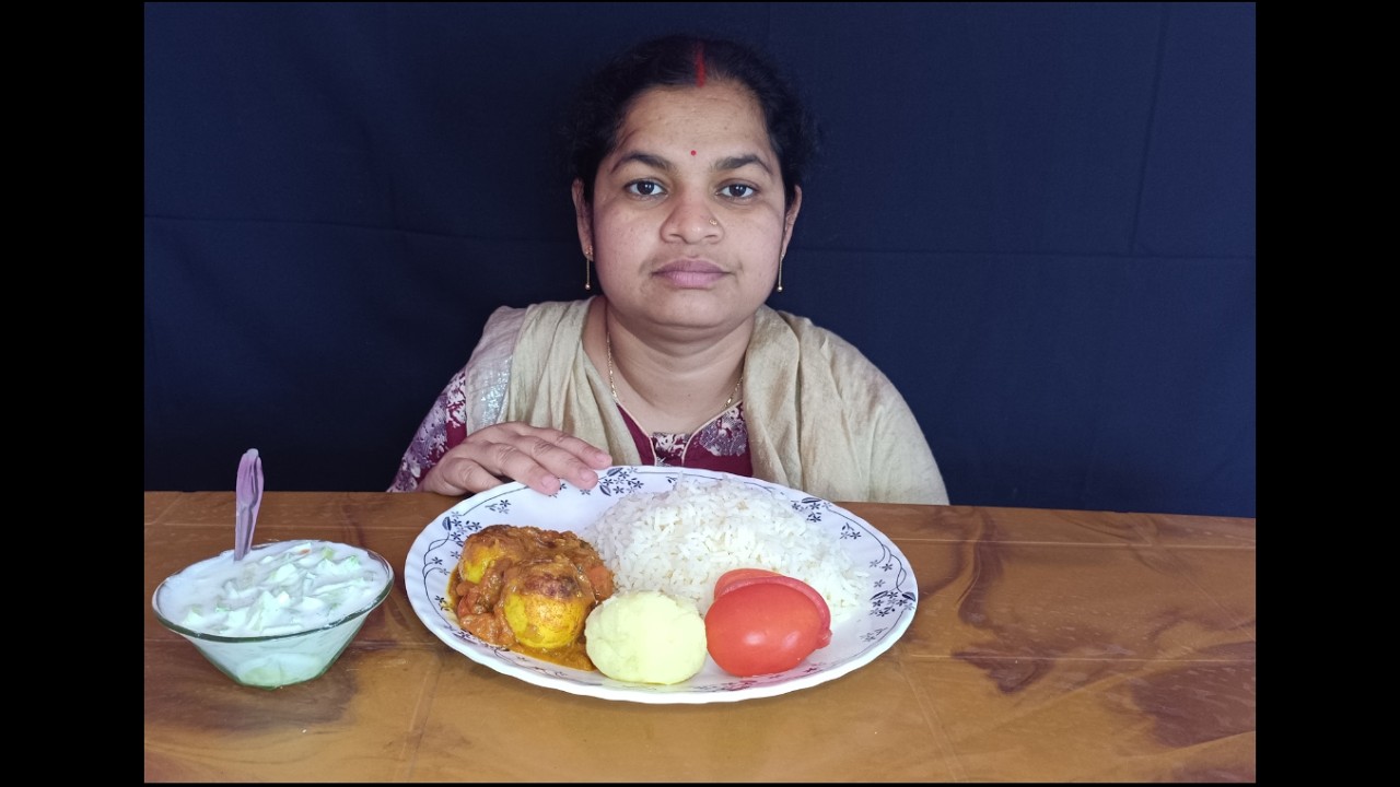 Basanti eating rice egg curry, aloo makha, raita