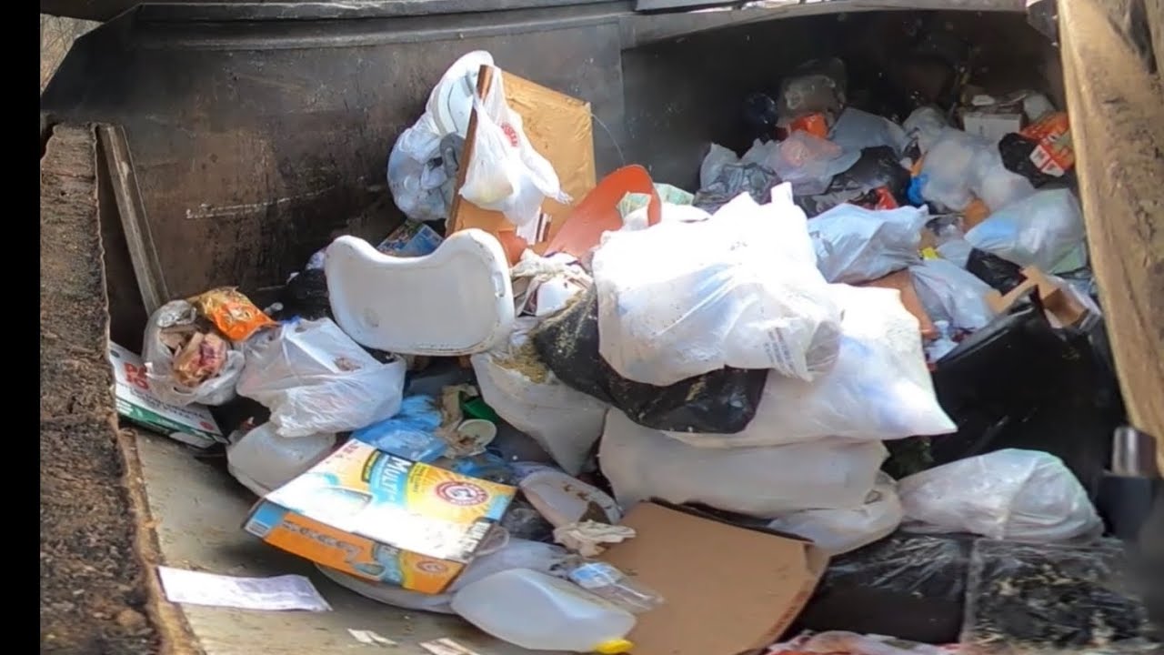 Dumpsters at apartments front loader garbage truck hopper view