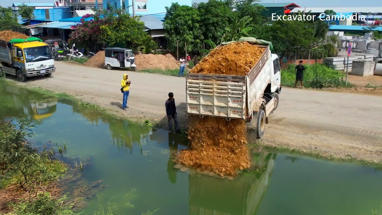 Video action pushing soil unloading soil landfill 100% full - Dump truck unloading soil stone