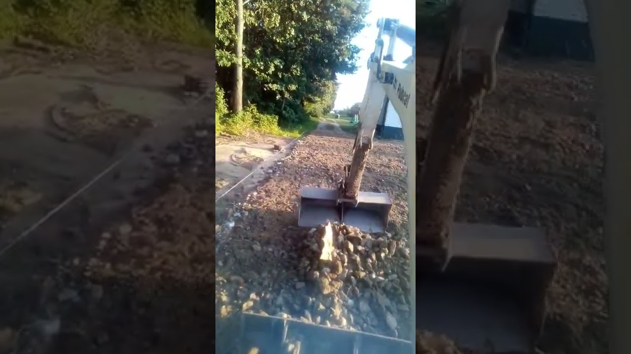 rozgarniamy ekologiczne kruszywo z recyklingu na działce minikoparką utwardzenie terenu walcem