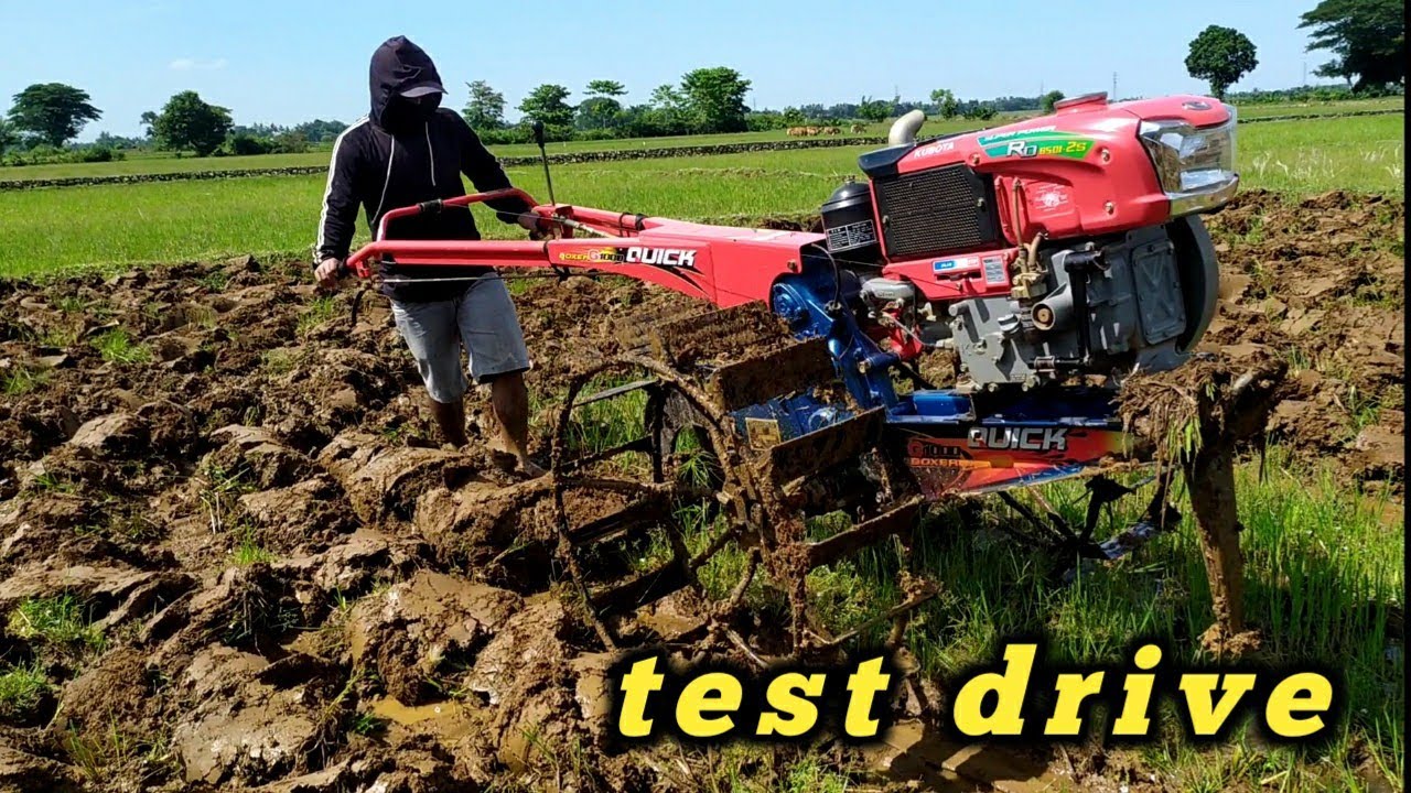 Traktor kubota g1000 boxer bekerja dengan santai mem bajak sawah