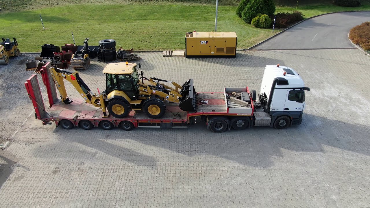 New CAT 444 backhoe [aerial view] pickup at the dealer and transport to the workshop for adjustment