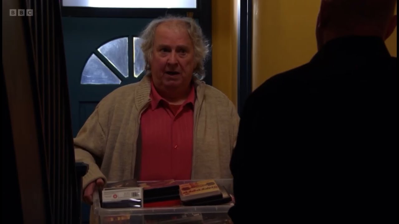 Eastenders Phil is angry with Nigel for dropping a photo of Peggy whilst moving boxes scene