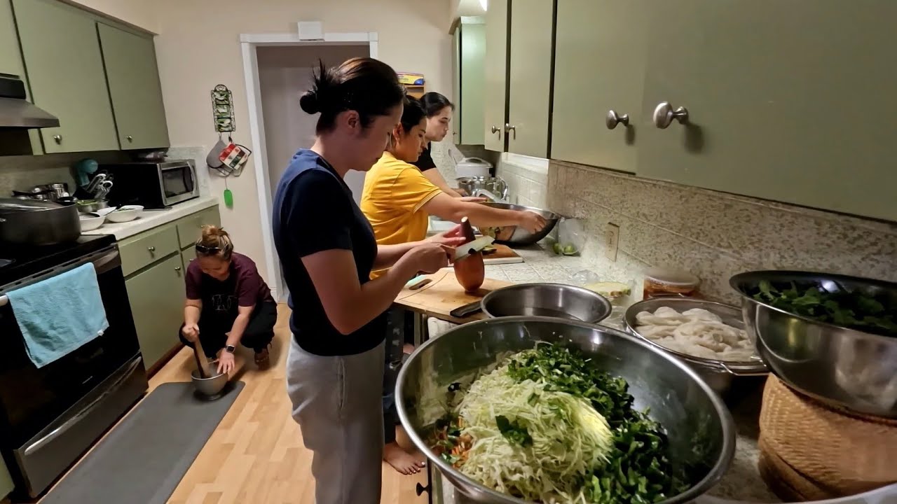 Lao women cook food for the men, making sour fish salad in the kitchen