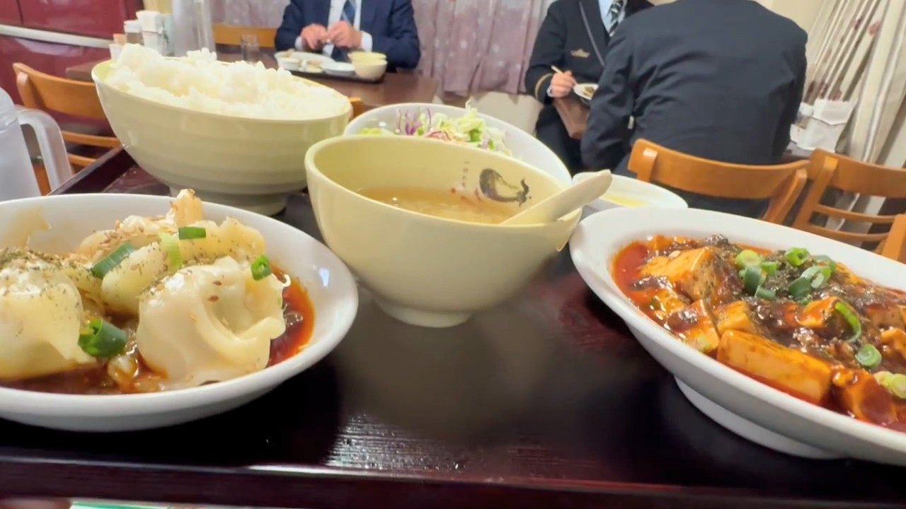 A Japanese salaryman enjoying mapo tofu  at a Chinese restaurant for his holiday lunch.