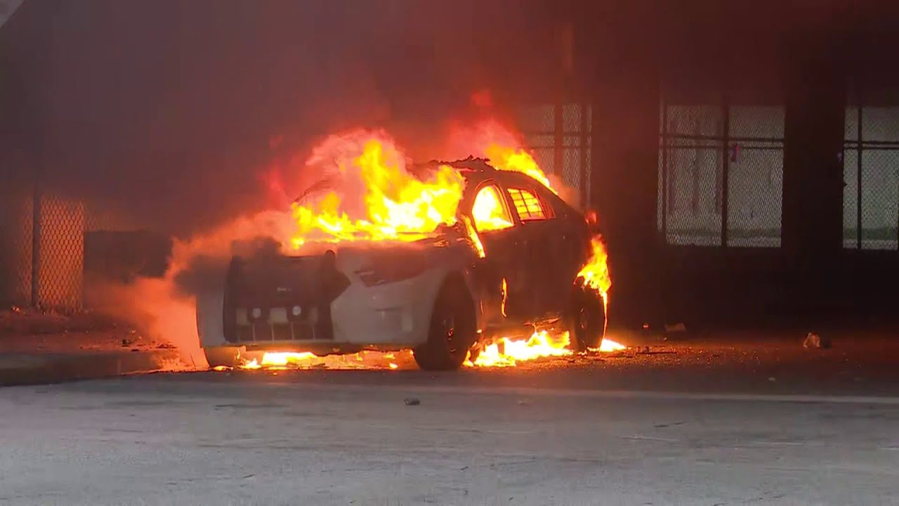 Raw video: Officers in riot gear stand guard as flames destroy police car during Miami protest
