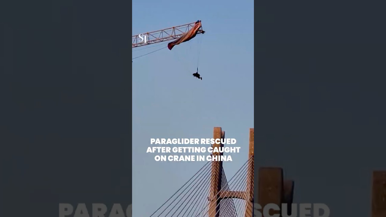 Paraglider rescued after getting caught on crane in China
