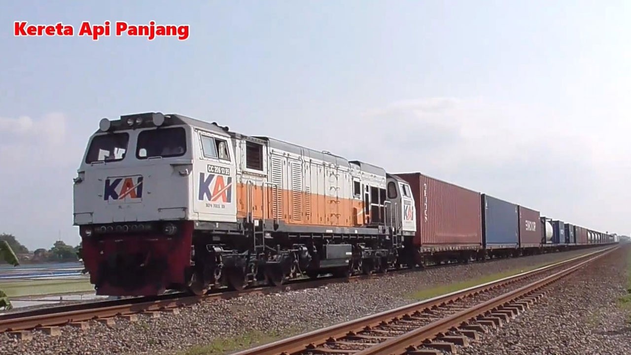 Kereta Api Panjang Lokomotif CC206 CC201 Melaju Cepat Melewati Perlintasan dan Jembatan