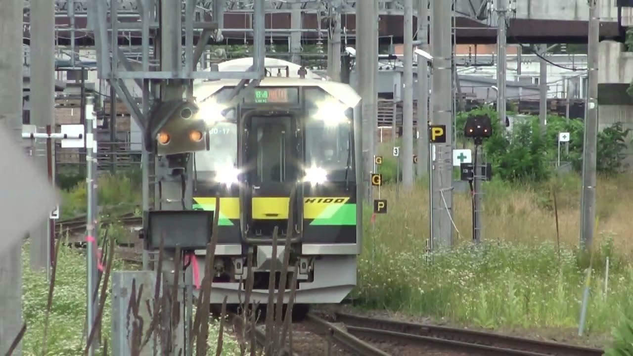 線路軌道に草が生い茂る宗谷本線に合流して新旭川駅に到着してくる石北本線上りH100形