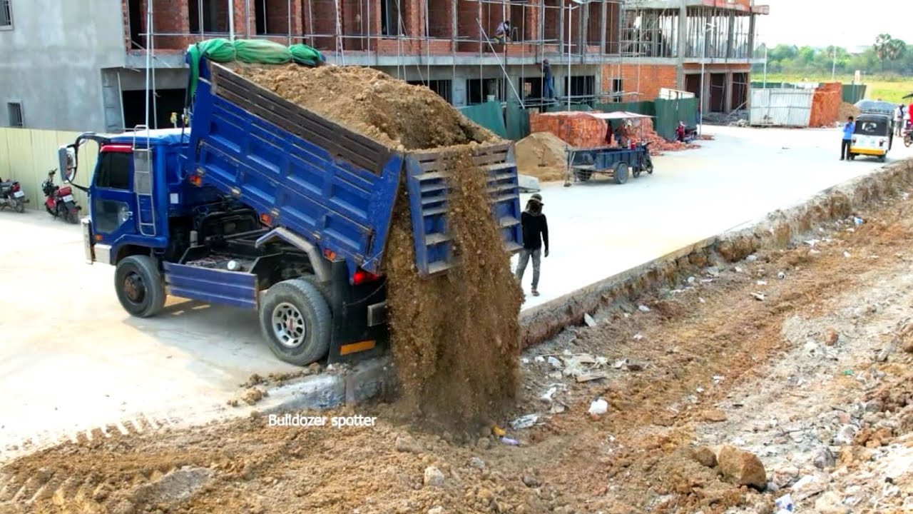 Great job !! Dump truck unloading soil landfilling build road and smart operator bulldozer pushing.