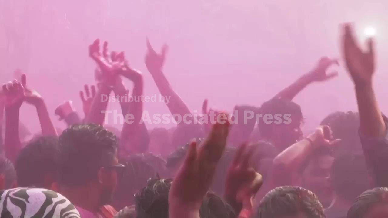 Colourful powder fills the air as an early Holi festival begins in India