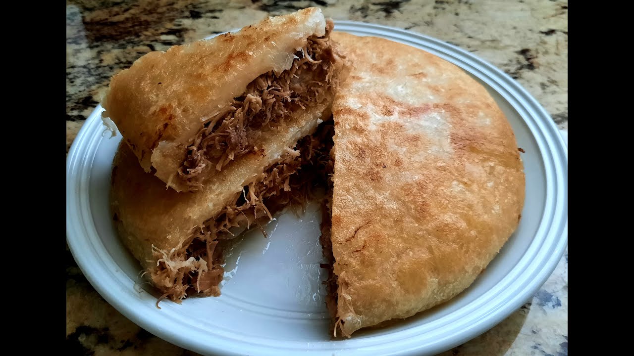 Tambor o Pastelón de yuca crujiente con carne de puerco y mojo de ajo.