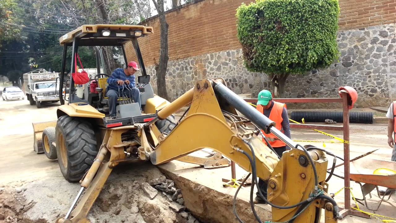 retroexcavadora levantando persona de zanja